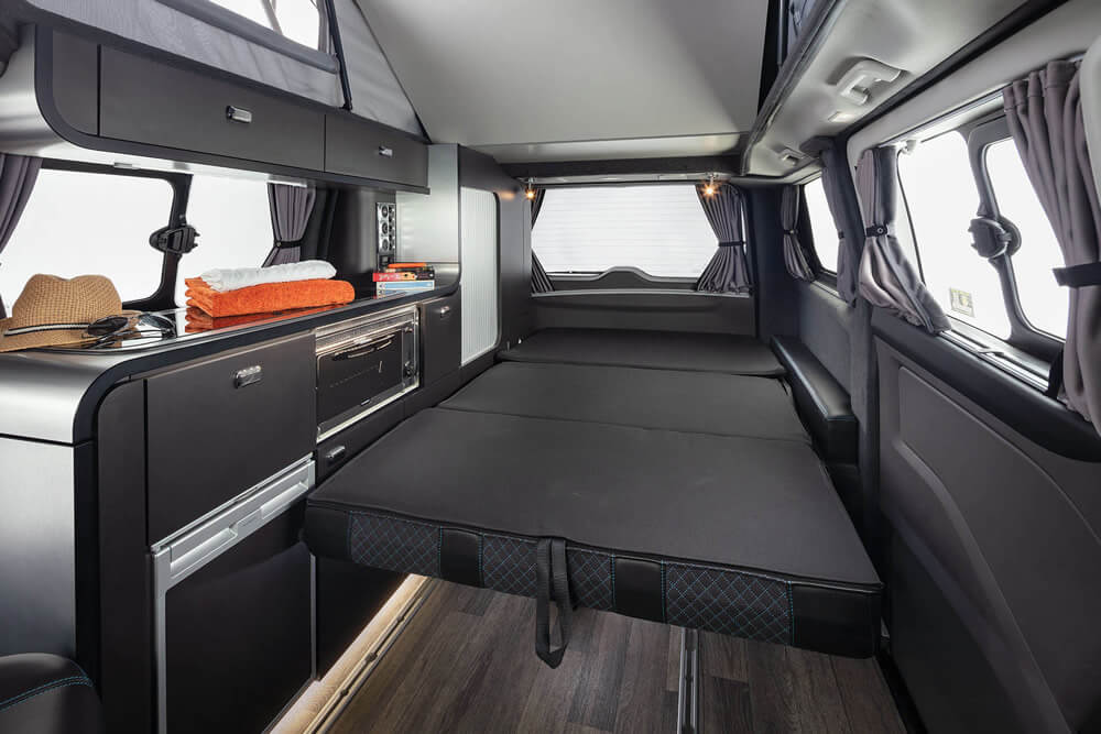 Monza rear seating area converted into a flat bed, showcasing MyBespoke Mattress custom-fit mattress for optimal comfort.