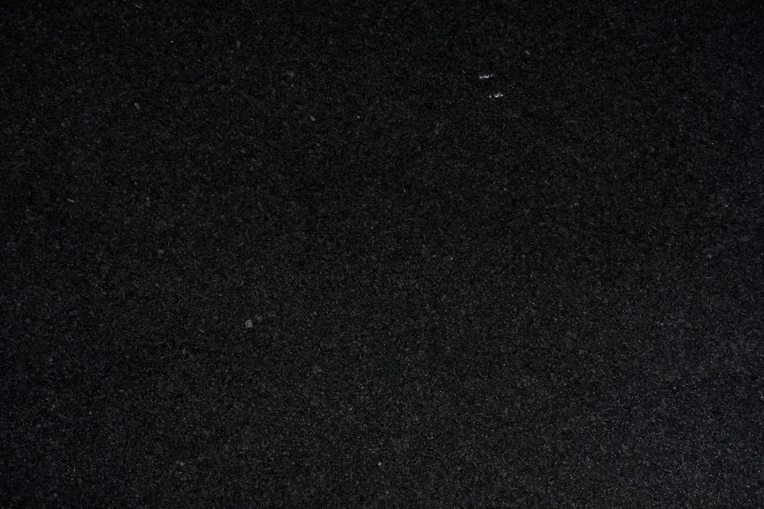 a close up of a black surface with a white object in the middle of it