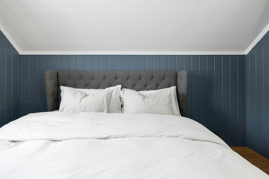 A bed with white pillows and white sheets