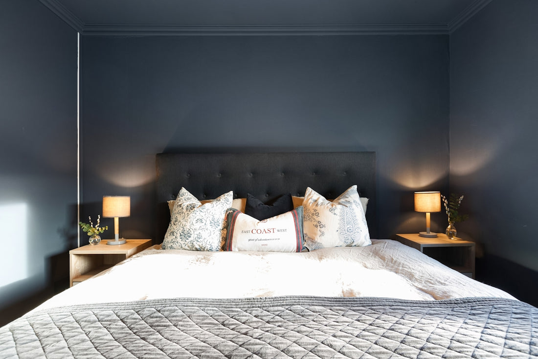 A bedroom with a bed and two lamps