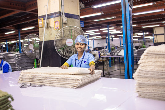 Factory worker smiling while making something.