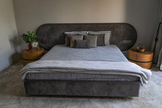 A modern bedroom shows a bed and furnishings.