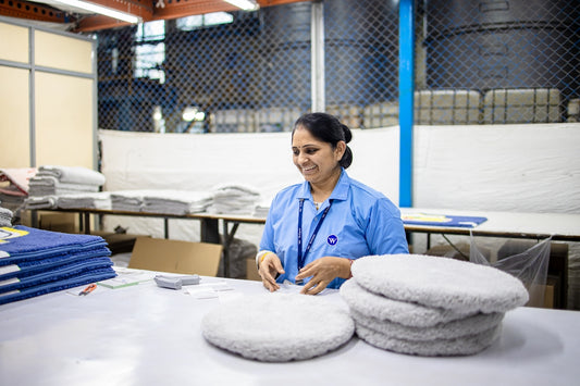 A worker is sorting and folding finished items.
