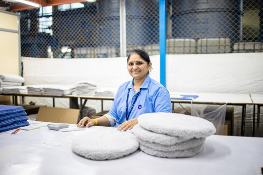 Woman smiles while working in a factory.