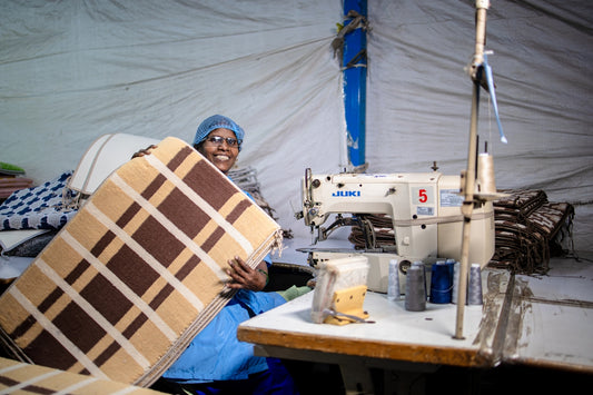 A woman sews cushions at a manufacturing facility.