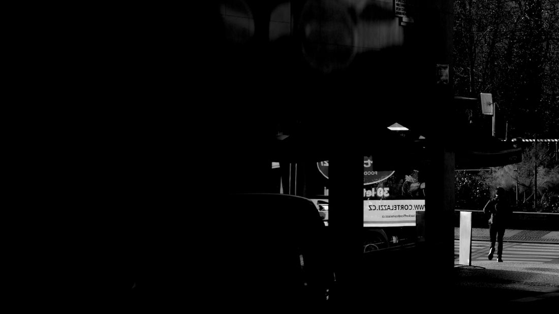 A lone figure walks past a dimly lit gas station.