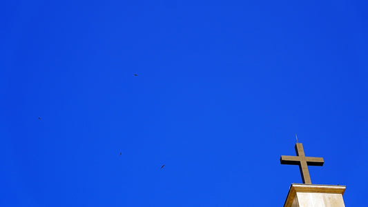 A cross on top of a building against blue sky