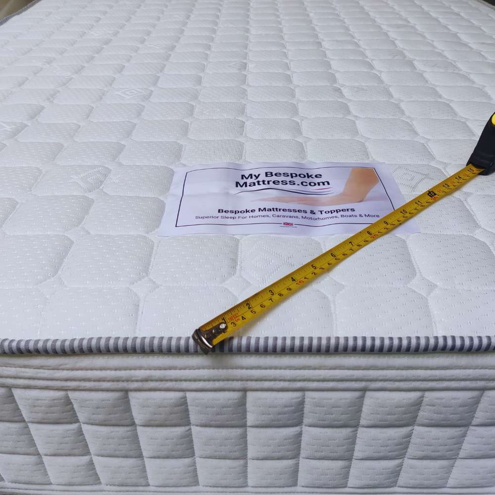Custom-shaped island bed mattress with curved foot-end, designed for caravans and motorhomes.