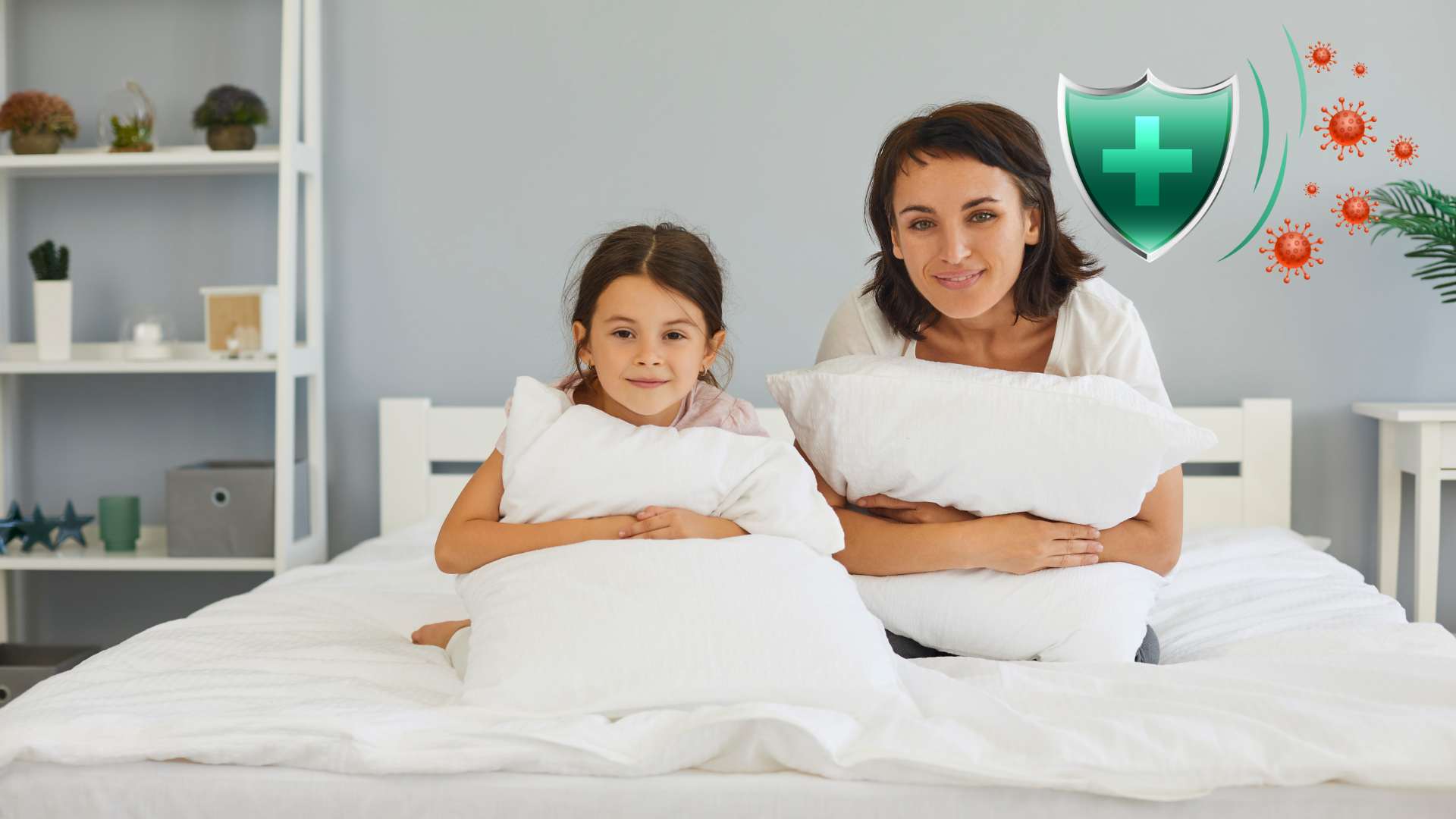 Mom and daughter smile while sitting up on a Viroclean® custom mattress. Green shield icon in top right corner signifies antiviral protection.