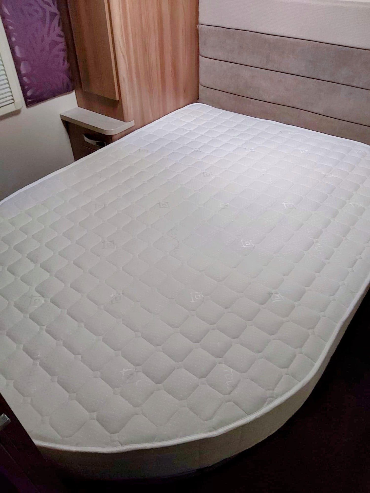 Island-shaped bespoke mattress tailored to fit a fixed bed base, showcased within the elegant interior of a luxurious 2023 caravan model.
