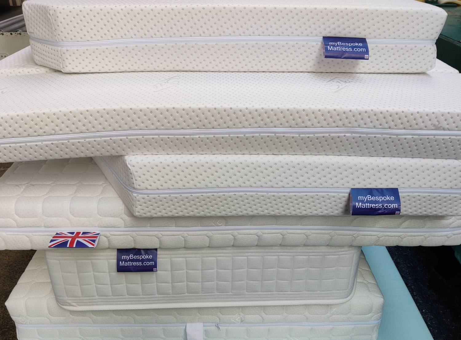 A big stack of custom size mattresses made for customers by Mybespokemattress
